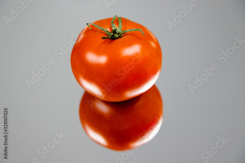 Soczysty pomidor na stole z efektem odbicia