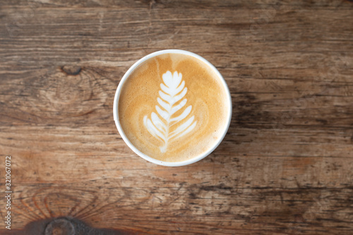 Topviews of a Late coffee cup on old wooden table background photo