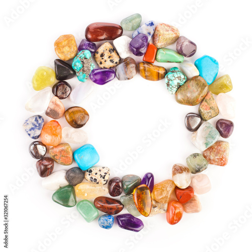 Circle made of colorful semiprecious gemstones isolated on a white background.