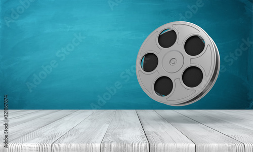 3d rendering of film reel on white wooden floor and dark turquoise background photo