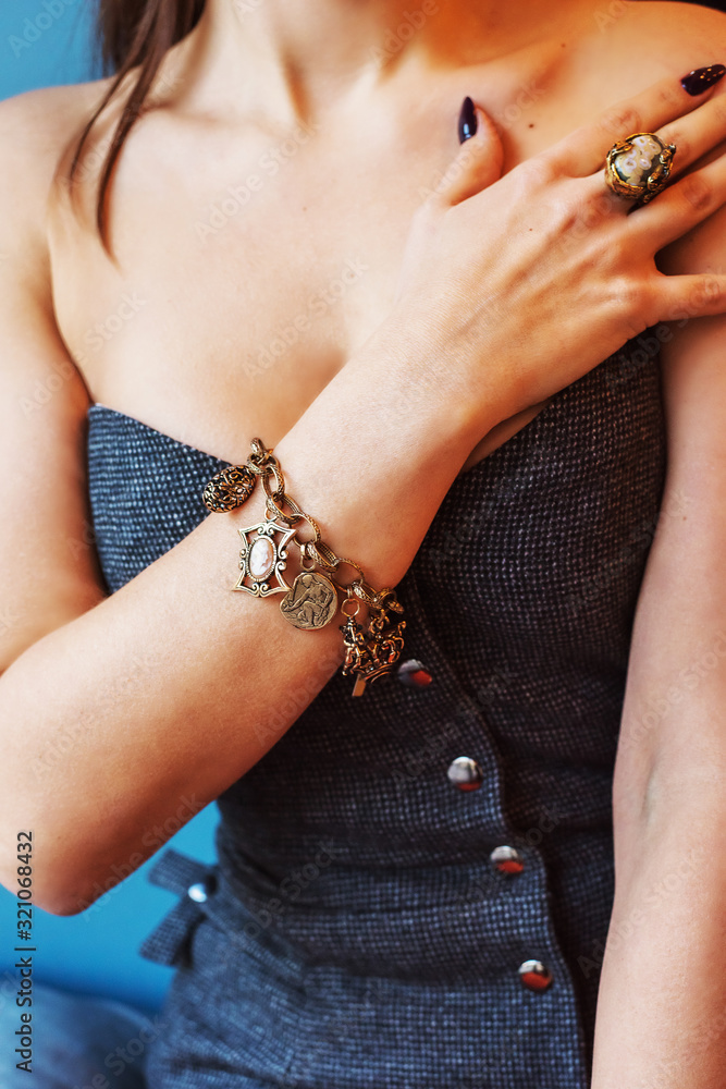Hands and body of a girl decorated with different decorative jewelry. Bracelet on a hand close-up.  Stylish accessories.