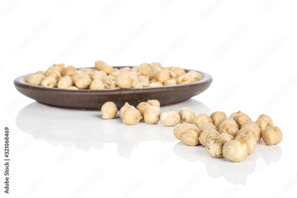 Lot of whole light fresh tan chickpea with brown ceramic coaster isolated on white background Lot of whole light fresh tan chickpea with brown ceramic coaster isolated on white background