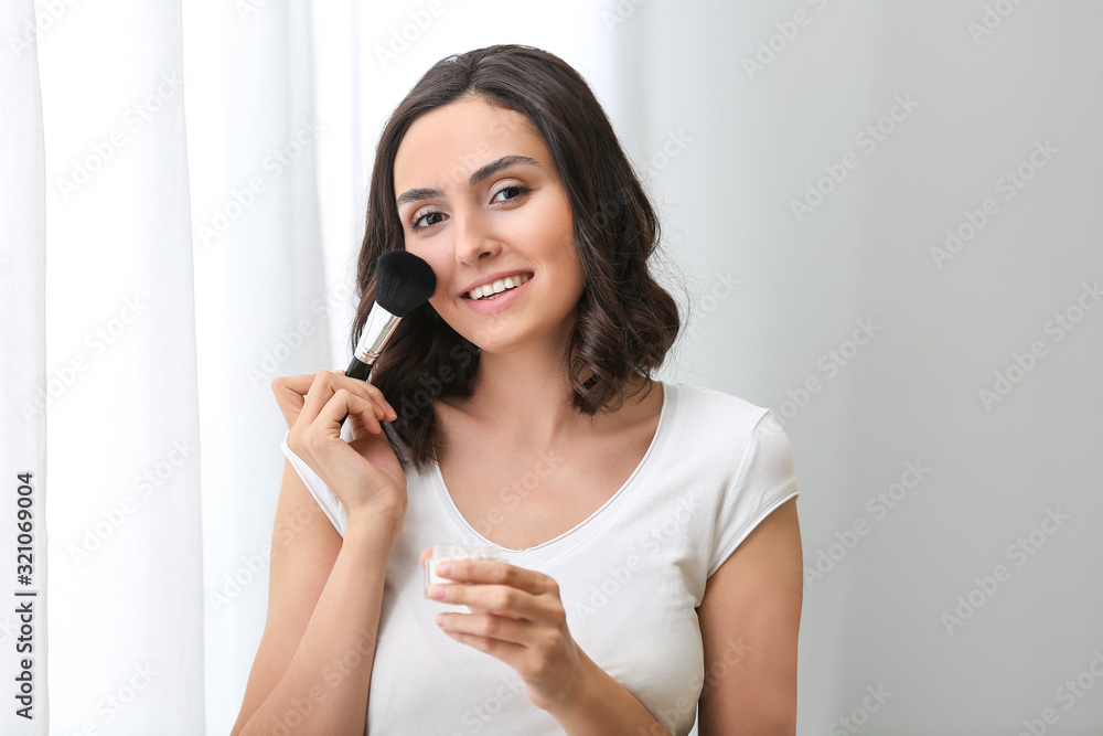 Beautiful young woman applying makeup at home Beautiful young woman applying makeup at home