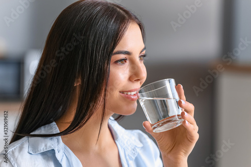 Beautiful young woman drink...