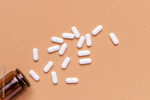 Bild auf Leinwand Film coated white oval pills spilled from bottle, top view