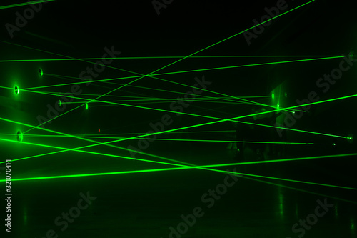 Green laser beams in a chaotic order from one wall to another.  Safety system