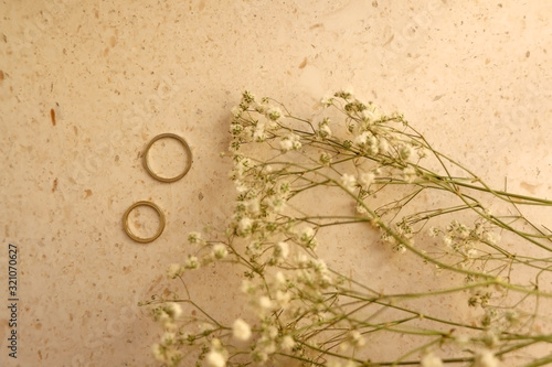 Two gold wedding rings on marble background. Top view. 