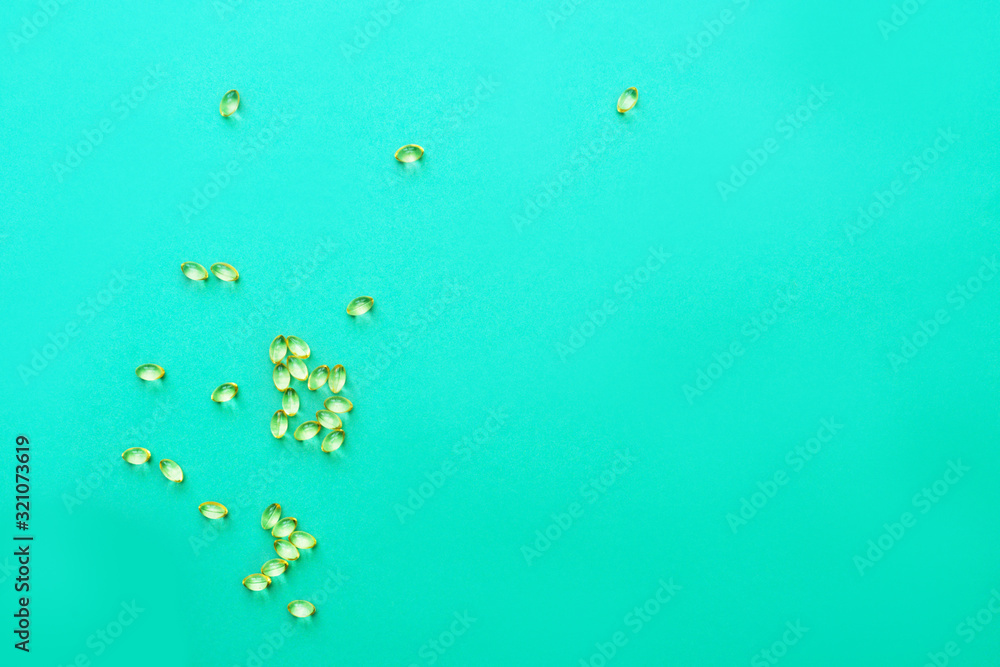 Vitamin D capsules on turquoise Vitamin D capsules on turquoise