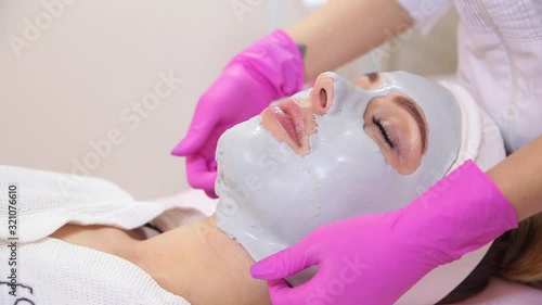 Beautiful woman with facial mask at beauty salon