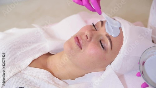 Beautiful woman with facial mask at beauty salon