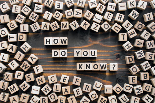 How do you know? - phrase from wooden blocks with letters, how do you know concept, random letters around, wooden background