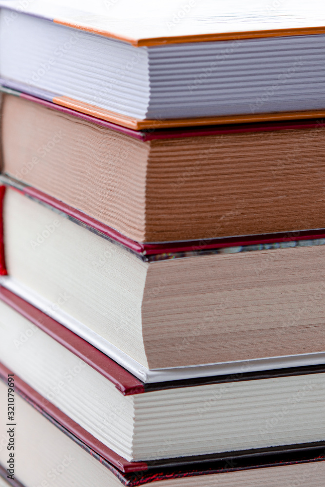 A lot of multi-colored books stand on a white wooden shelf against the backdrop of winter forest A lot of multi-colored books stand on a white wooden shelf against the backdrop of winter forest