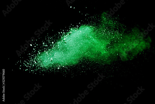 Green powder explosion on black background.