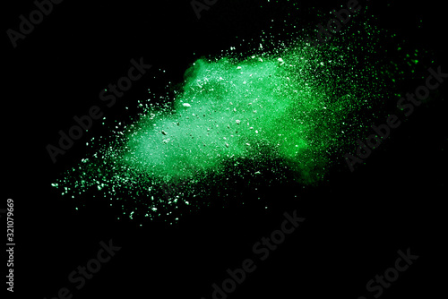 Green powder explosion on black background.