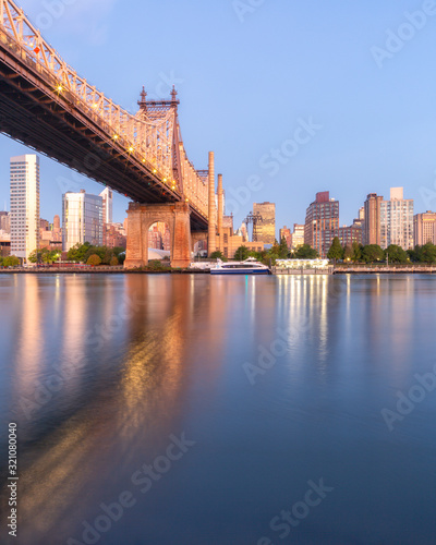 Queensboro Bridge and Roosevelt Island at sunrise from East river with long exposure