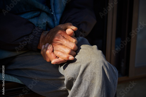 Old man's hands sitting at porch