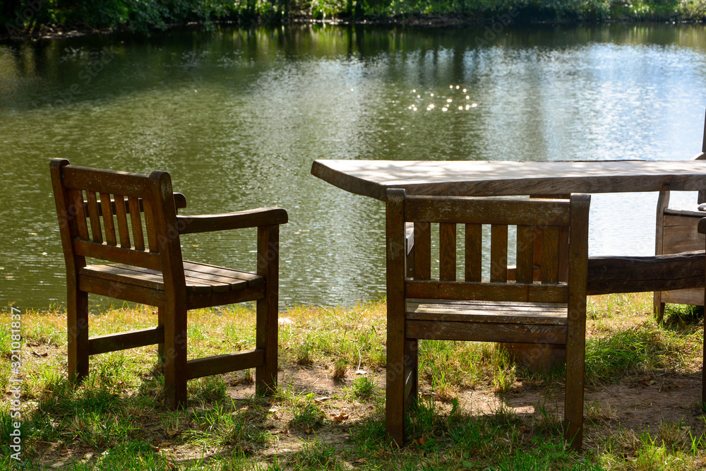 Two empty garden chair with table by a lake