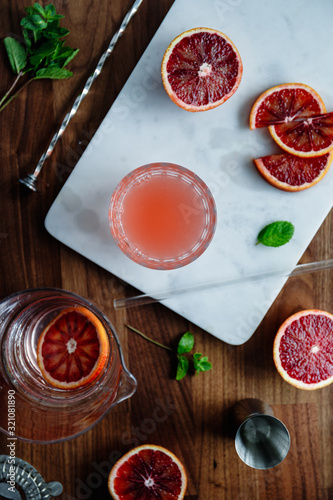 Refreshing cold summer cocktail with blood orange and mint on a marble tray. Top view, flat lay composition.