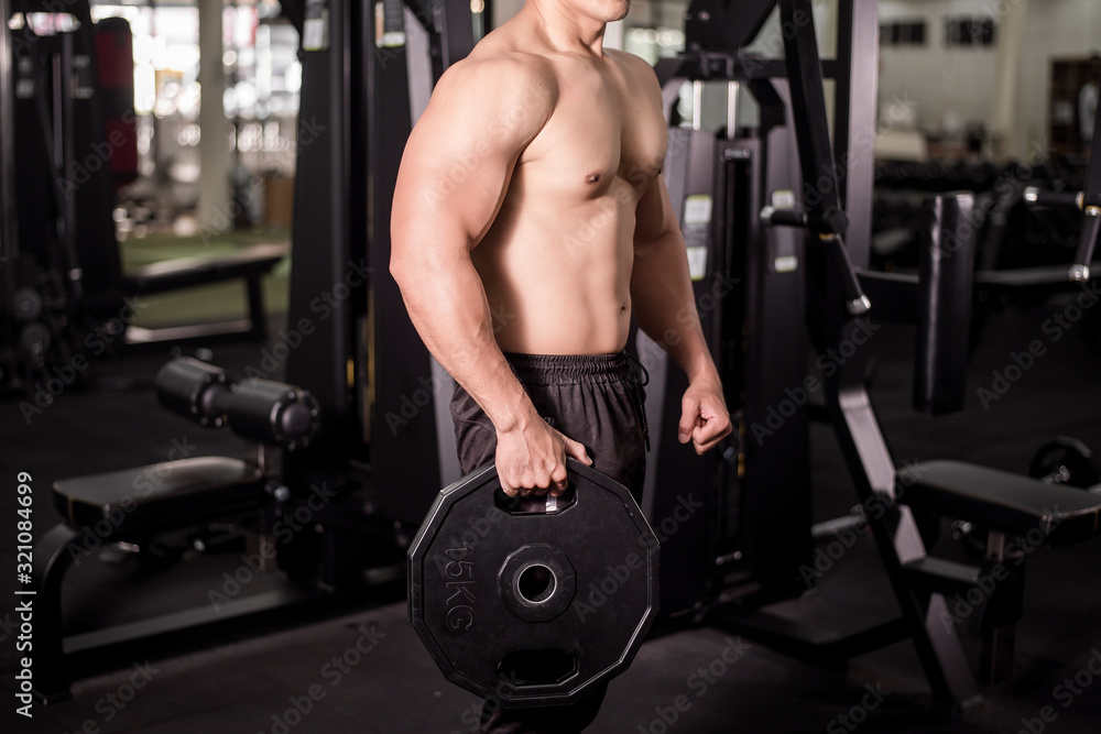 Naklejka premium Muscular fitness man bodybuilder is workout in gym