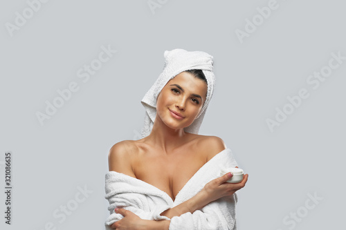 Quadro su tela Woman in bathrobe holding cream jar.