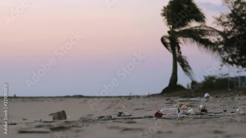 Dirty tropical beach with trash, litter and plastic waste on the sand washed out by the ocean to the shore. photo