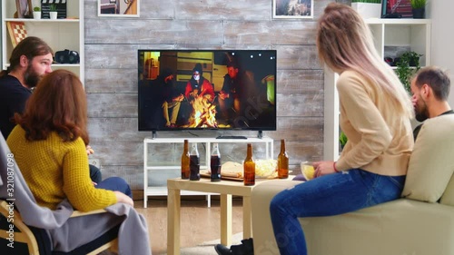 Rear view of blonde woman with her friends watching a tv show photo