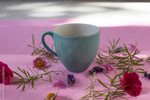 cup of coffee tea with flowers on pink background 