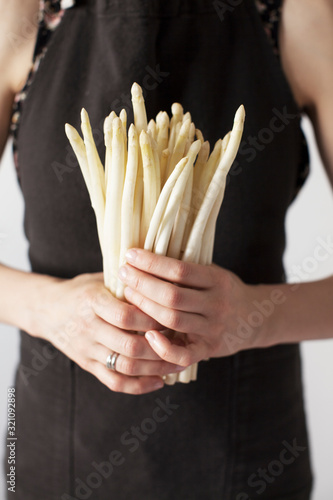 woman holding white asparagus in her hands