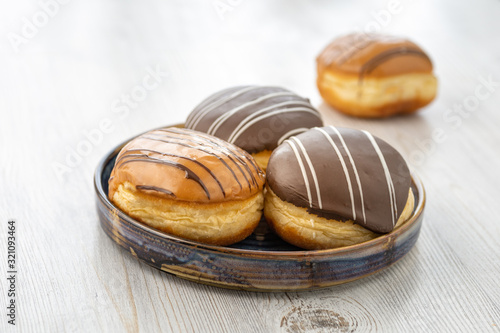 Donut or bun made from sweet yeast dough stuffed with chocolate or cream with icing. Confectionery - Berliner Pfannkuchen.