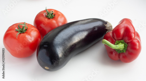 Vegetables eggplant, bell pepper and tomatoes on a white background