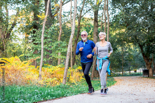 Mature couple man and woman jogging in the park
