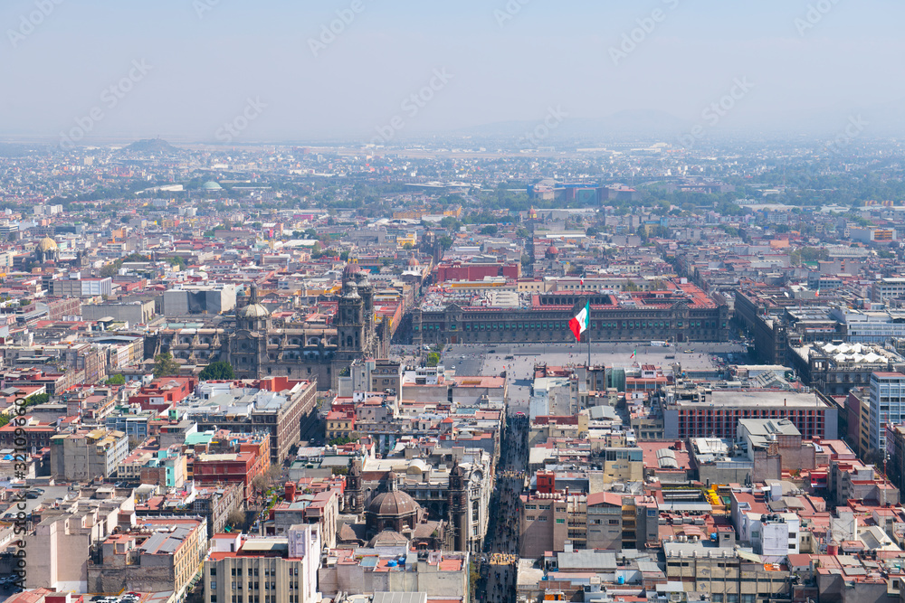 Mexico National Flag on Zocalo Constitution Square and Metropolitan Cathedral aerial view, from Torre Latinoamericana, Mexico City, Mexico. Historic center of Mexico City is a World Heritage Site. 