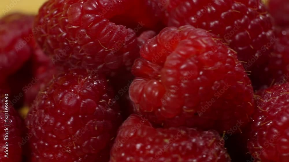 Fresh raspberries are spinning in a circle on a yellow background. Raspberry rotation over yellow background. Fresh raspberries are spinning in a circle on a yellow background. Raspberry rotation over yellow background.
