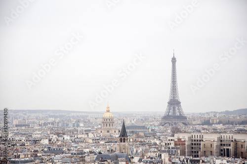 Scenic view over the Paris roofs with Eiffel Tower in background on a hazy day with the overcast sky.