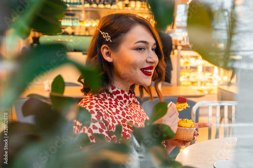 Beautiful Brunette Woman Celebrating Saint Valentine Day Alone With Cupcake In Stylish Cafe. photo