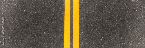 Black asphalt road texture with marking background. Double yellow line on asphalt road. © lllonajalll