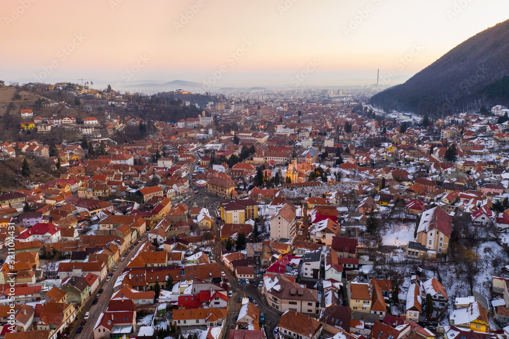 Aerial drone shot of Brasov old town at sunrise on a beautiful winter morning