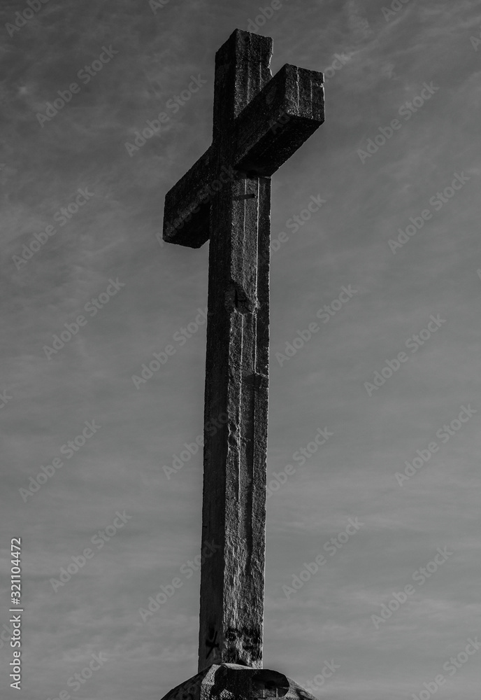 Fototapeta premium cross in the middle of a mountain receiving the sun's rays