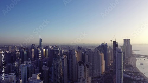 Wallpaper Mural Aerial view of Dubai city. Drone fly over futuristic Dubai Marina district on beautiful sunset. Residential Modern skyscraper buildings, Jumeirah Beach, UAE, Middle East smart city Torontodigital.ca