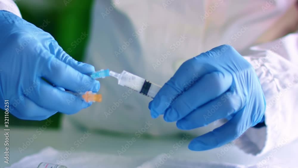 Nurse inserts syringe needle for injection Nurse inserts syringe needle for injection