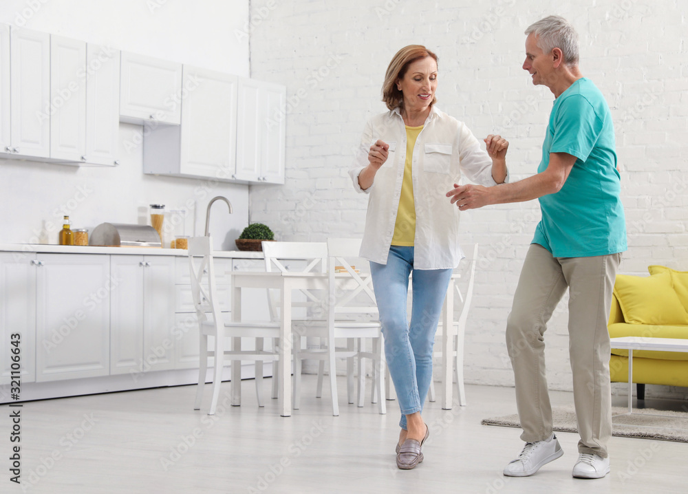 Happy senior couple dancing in kitchen at home Happy senior couple dancing in kitchen at home