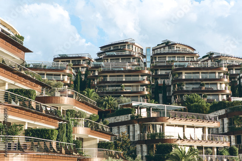 View of a modern hotel in Budva in Montenegro with many windows and balconies and plants.
