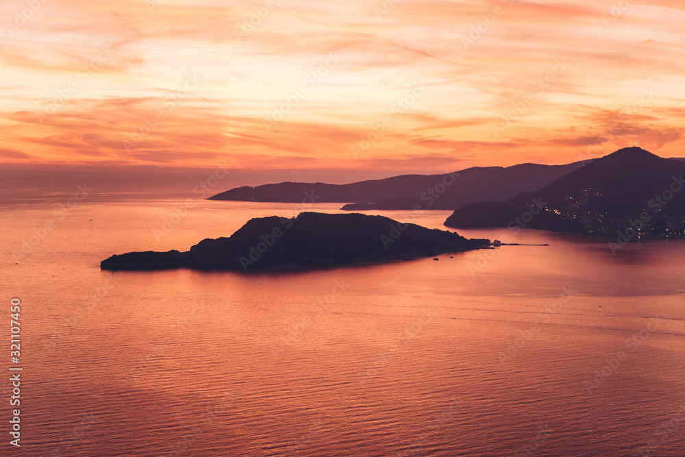 Beautiful view of the sunset and the natural landscape with the sea and hills or mountains in Montenegro.
