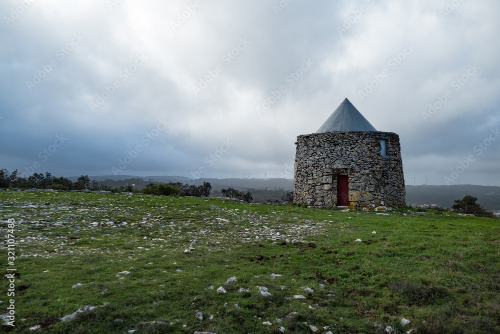 abandoned traditional windmill in a windy landscape