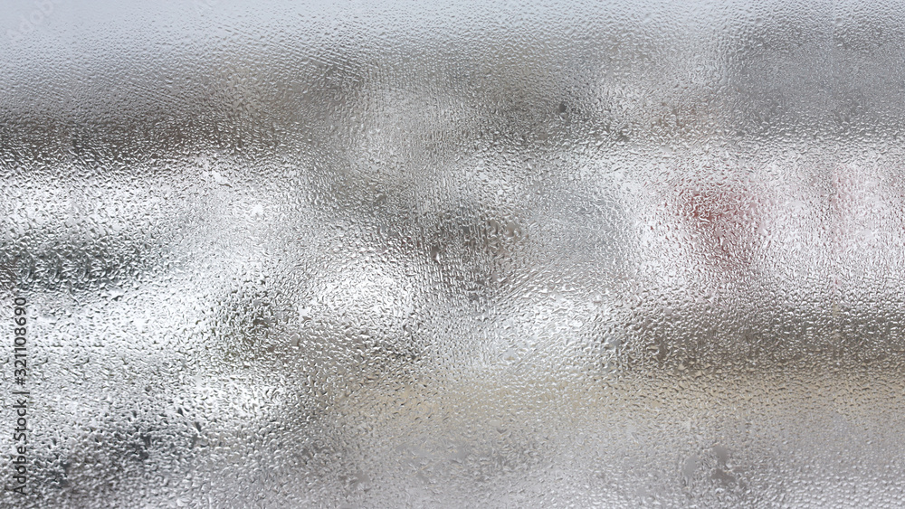 High humidity in the form of condensation on a transparent glass with large drops of natural water. Defective plastic window with condensation