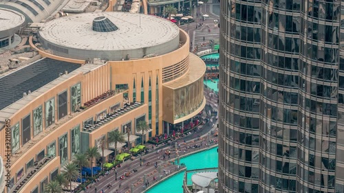 Lots of tourists walking near foutains and shopping mall in Dubai downtown night timelapse. Aerial view to one of the largest shopping malls in the world. Balcony with viewpoint photo