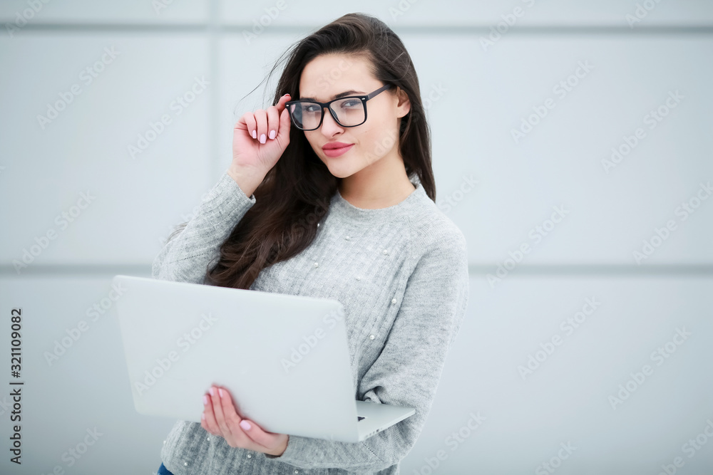 A woman with a laptop in her hands close up with long hair and glasses on her eyes. A woman with a laptop in her hands close up with long hair and glasses on her eyes.