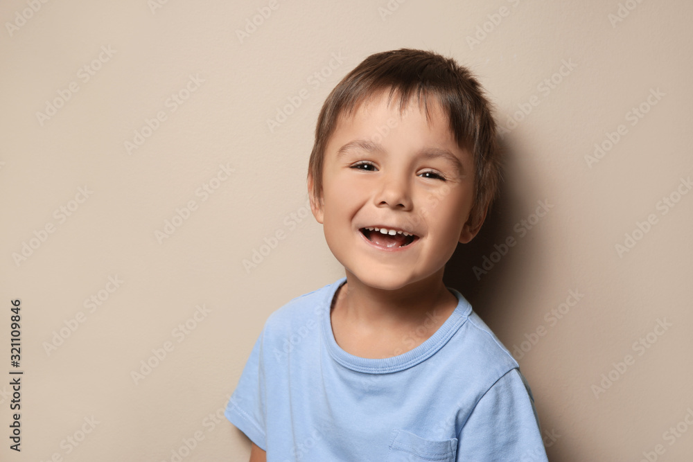 Portrait of cute little boy on beige background Portrait of cute little boy on beige background