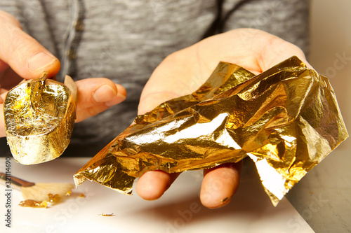 Artwork of gilding - covering an object with plate metal gold photo