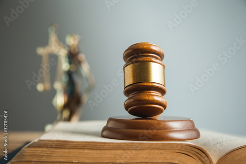 wooden judge on book with justice lady on desk